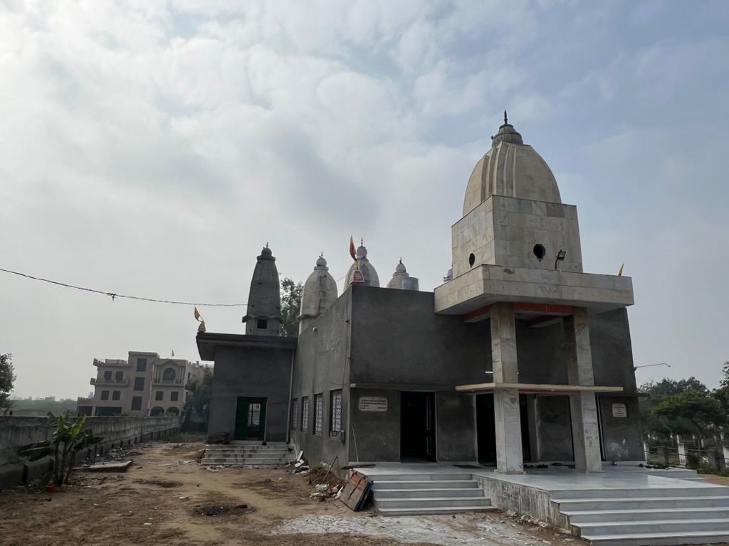 The new temple at Hansi Gita Bhawan from the side during construction, rubble and bare earth still in front of the steps